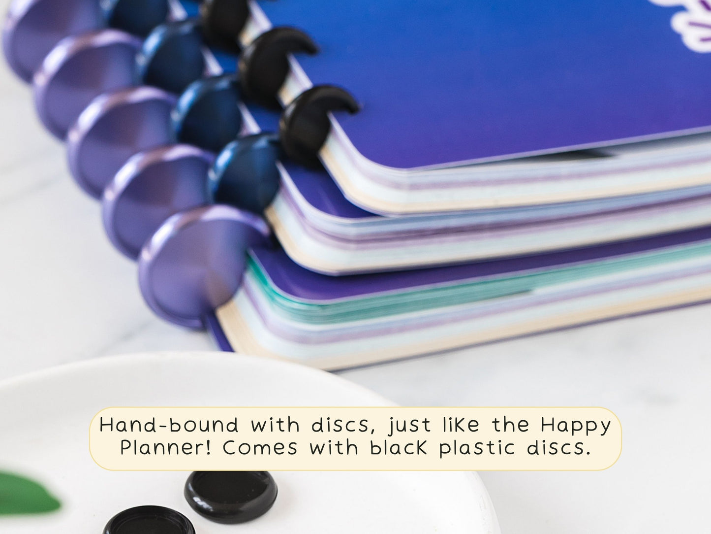 Stack of three K-Drama Bingo Discbound Journal close up to the discs  used for the binding, with note that the journal comes with lack plastic discs.